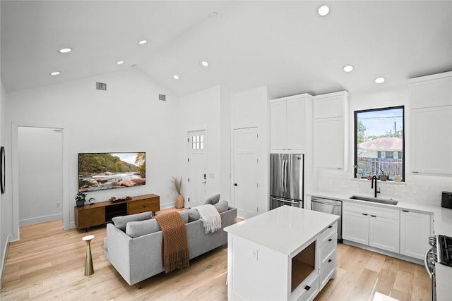 2216 Lindell Ave Unit 2, Austin, TX 78704 - kitchen featuring stainless steel appliances, white cabinets, recessed lighting, light countertops, and a center island