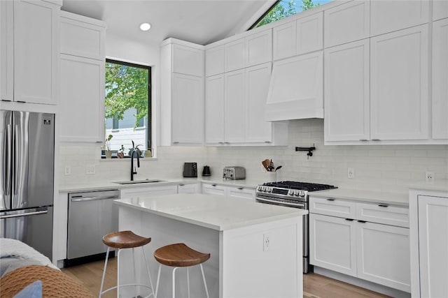 2216 Lindell Ave Unit 2, Austin, TX 78704 - kitchen featuring appliances with stainless steel finishes, light wood-type flooring, white cabinets, recessed lighting, and lofted ceiling