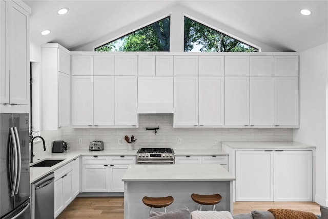2216 Lindell Ave Unit 2, Austin, TX 78704 - kitchen featuring stainless steel appliances, lofted ceiling, backsplash, light countertops, and white cabinetry