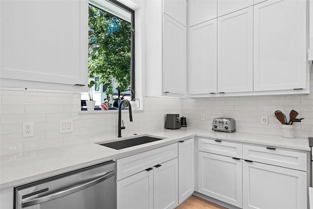 2216 Lindell Ave Unit 2, Austin, TX 78704 - kitchen featuring dishwasher, backsplash, light countertops, and white cabinetry