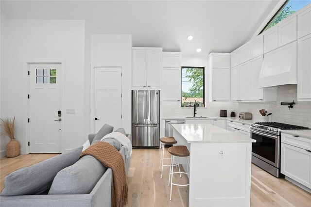 2216 Lindell Ave Unit 2, Austin, TX 78704 - kitchen featuring appliances with stainless steel finishes, decorative backsplash, a kitchen bar, recessed lighting, and white cabinets