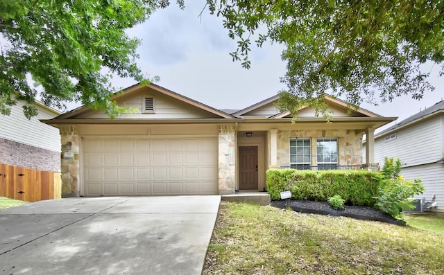 371 Bloomsbury Dr, Kyle, TX 78640 - ranch-style home featuring stone siding, an attached garage, and driveway