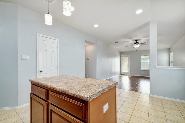 371 Bloomsbury Dr, Kyle, TX 78640 - kitchen featuring ceiling fan, light tile patterned floors, a center island, light countertops, and decorative light fixtures