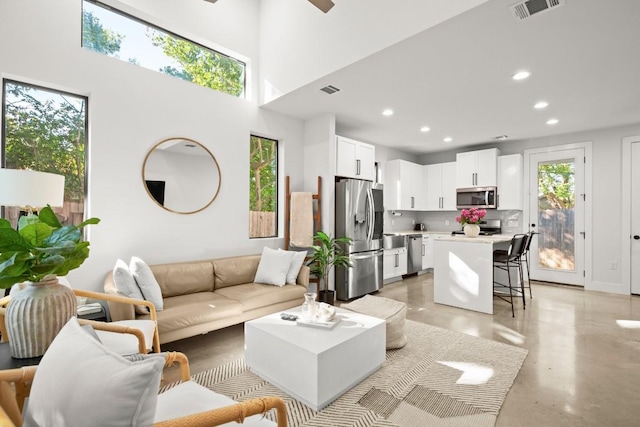 619 Hammack Dr Unit 2, Austin, TX 78752 - living area featuring concrete floors, recessed lighting, ceiling fan, and a towering ceiling