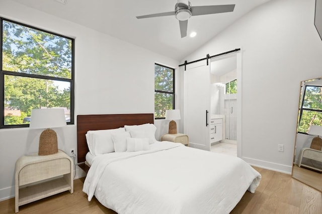 619 Hammack Dr Unit 2, Austin, TX 78752 - bedroom featuring a barn door, vaulted ceiling, light wood finished floors, ensuite bathroom, and a ceiling fan
