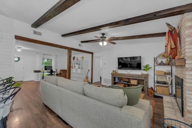 409 White Wing Way, Round Rock, TX 78664 - living area with a brick fireplace, wood finished floors, a ceiling fan, and beamed ceiling
