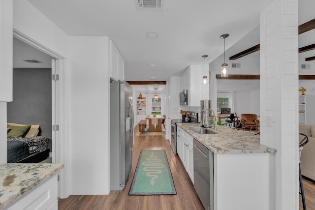 409 White Wing Way, Round Rock, TX 78664 - kitchen featuring stainless steel appliances, wood finished floors, and white cabinets