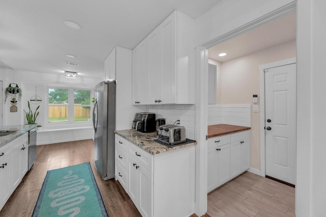 409 White Wing Way, Round Rock, TX 78664 - kitchen featuring stainless steel appliances, white cabinetry, light wood finished floors, tasteful backsplash, and recessed lighting