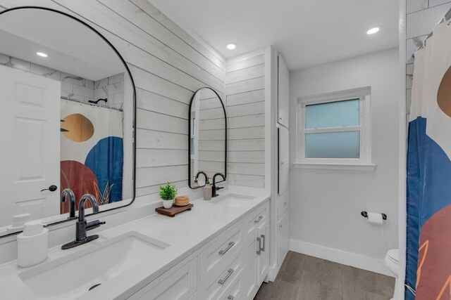 409 White Wing Way, Round Rock, TX 78664 - full bathroom with double vanity, wood finished floors, recessed lighting, and a shower with shower curtain