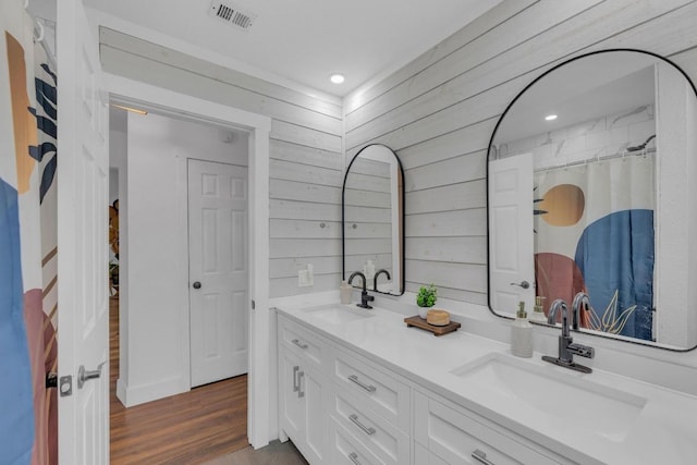 409 White Wing Way, Round Rock, TX 78664 - bathroom featuring double vanity, wooden walls, wood finished floors, and recessed lighting