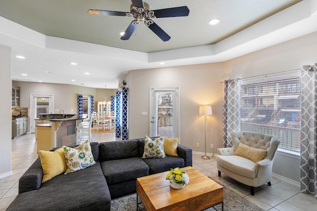 521 Lucy Ln, Horseshoe Bay, TX 78657 - living room with light tile patterned floors, a ceiling fan, recessed lighting, and a tray ceiling