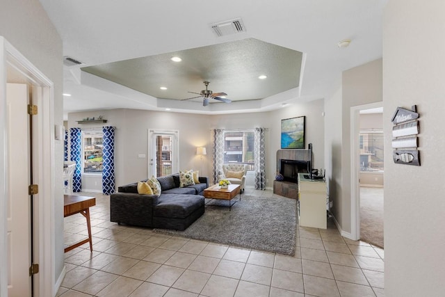 521 Lucy Ln, Horseshoe Bay, TX 78657 - living area with a raised ceiling, ceiling fan, light tile patterned flooring, a fireplace with raised hearth, and recessed lighting