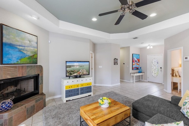 521 Lucy Ln, Horseshoe Bay, TX 78657 - living area with light tile patterned floors, a tiled fireplace, ceiling fan, a raised ceiling, and recessed lighting