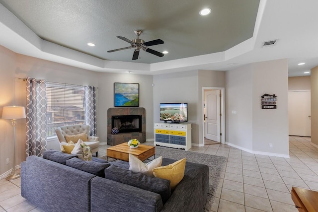 521 Lucy Ln, Horseshoe Bay, TX 78657 - living area featuring a tray ceiling, light tile patterned floors, a ceiling fan, recessed lighting, and a tiled fireplace