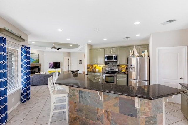 521 Lucy Ln, Horseshoe Bay, TX 78657 - kitchen featuring stainless steel appliances, light tile patterned floors, a kitchen bar, tasteful backsplash, and recessed lighting