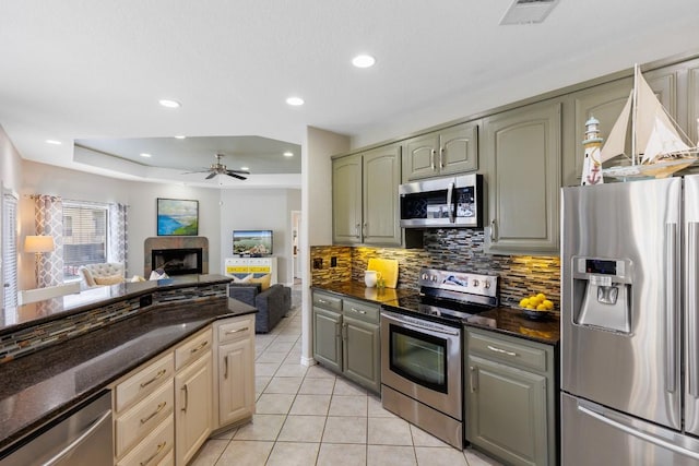 521 Lucy Ln, Horseshoe Bay, TX 78657 - kitchen with appliances with stainless steel finishes, ceiling fan, decorative backsplash, light tile patterned floors, and open floor plan