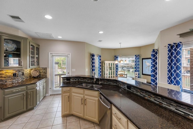 521 Lucy Ln, Horseshoe Bay, TX 78657 - kitchen with stainless steel dishwasher, light tile patterned floors, tasteful backsplash, dark stone counters, and glass insert cabinets