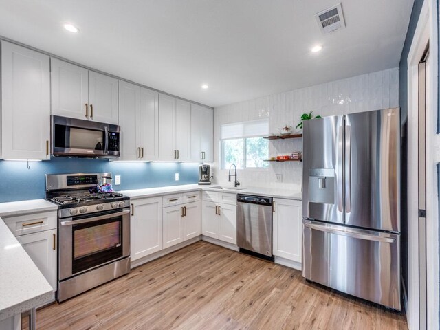 11405 Bristle Oak Trl, Austin, TX 78750 - kitchen featuring stainless steel appliances, light wood-style floors, tasteful backsplash, white cabinets, and recessed lighting