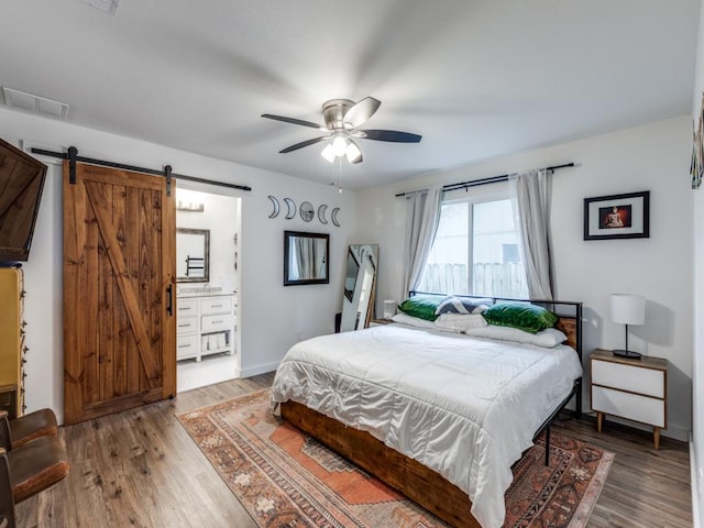 11405 Bristle Oak Trl, Austin, TX 78750 - bedroom featuring a barn door, light wood-type flooring, a ceiling fan, and ensuite bathroom