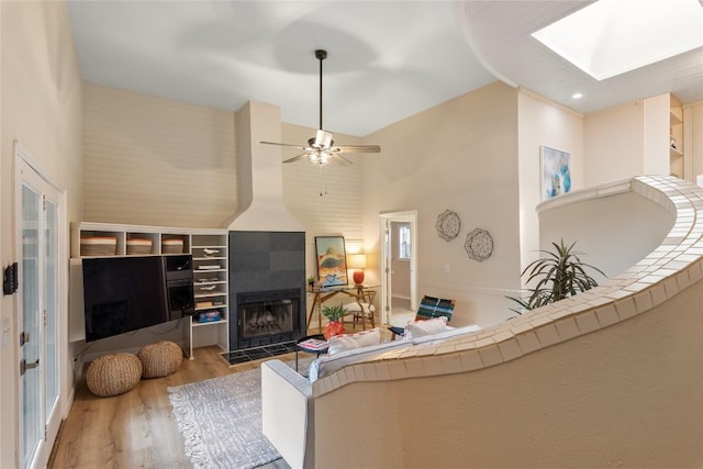 2206 Newfield Ln, Austin, TX 78703 - living area with wood finished floors, a fireplace, a skylight, a ceiling fan, and high vaulted ceiling