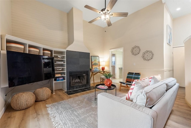 2206 Newfield Ln, Austin, TX 78703 - living room featuring a high ceiling, wood finished floors, ceiling fan, and a tile fireplace