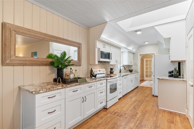 2206 Newfield Ln, Austin, TX 78703 - kitchen with white appliances, a skylight, white cabinetry, and light wood finished floors