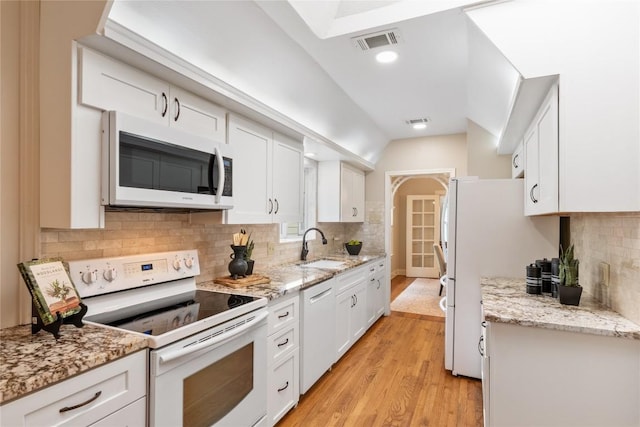 2206 Newfield Ln, Austin, TX 78703 - kitchen with white appliances, white cabinets, tasteful backsplash, light wood-style floors, and recessed lighting