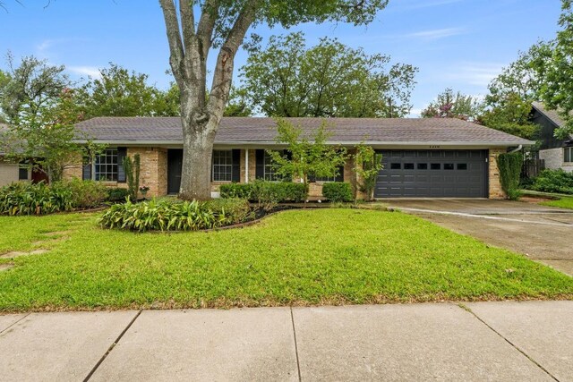7710 Shoal Creek Blvd, Austin, TX 78757 - single story home featuring an attached garage, brick siding, a front lawn, and driveway