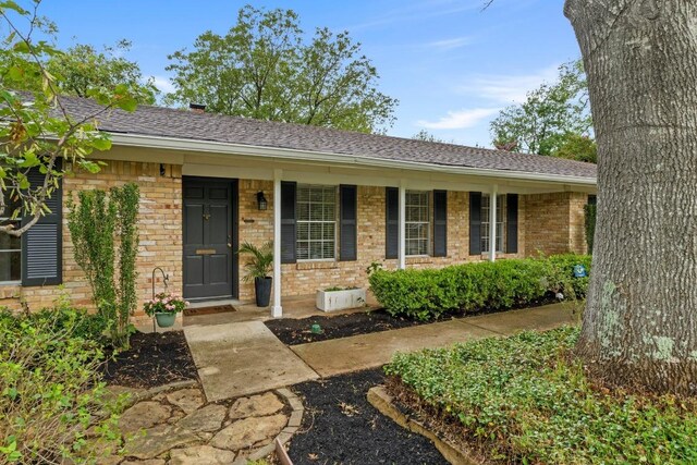 7710 Shoal Creek Blvd, Austin, TX 78757 - single story home with brick siding, a porch, and roof with shingles