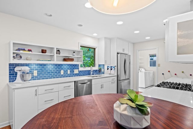 7710 Shoal Creek Blvd, Austin, TX 78757 - kitchen featuring appliances with stainless steel finishes, washer and dryer, tasteful backsplash, white cabinetry, and recessed lighting