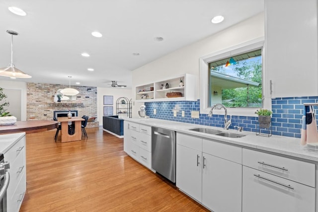 7710 Shoal Creek Blvd, Austin, TX 78757 - kitchen with appliances with stainless steel finishes, a fireplace, white cabinets, decorative backsplash, and decorative light fixtures