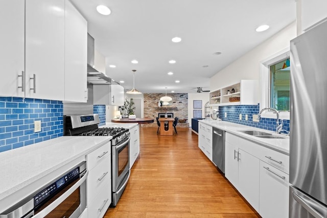 7710 Shoal Creek Blvd, Austin, TX 78757 - kitchen featuring stainless steel appliances, wall chimney exhaust hood, backsplash, white cabinetry, and recessed lighting