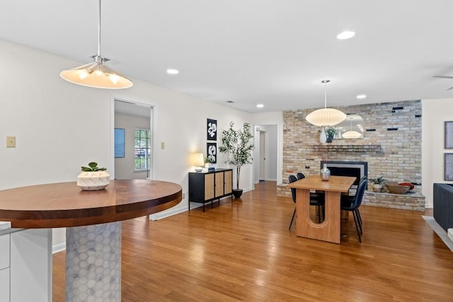 7710 Shoal Creek Blvd, Austin, TX 78757 - dining space with wood finished floors, a fireplace, recessed lighting, and a ceiling fan