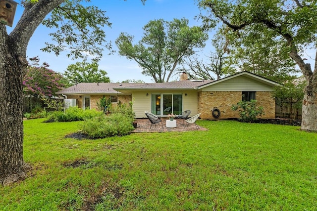 7710 Shoal Creek Blvd, Austin, TX 78757 - back of house featuring brick siding, a lawn, a patio area, and a chimney