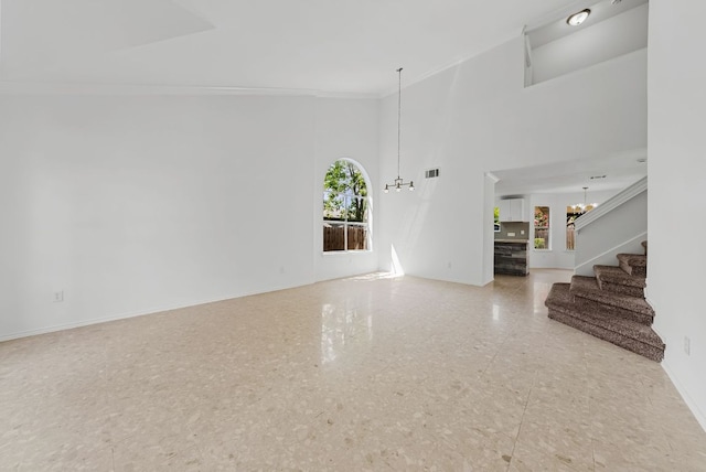 1213 Pathfinder Way, Round Rock, TX 78665 - unfurnished living room with a chandelier, stairway, crown molding, and a towering ceiling