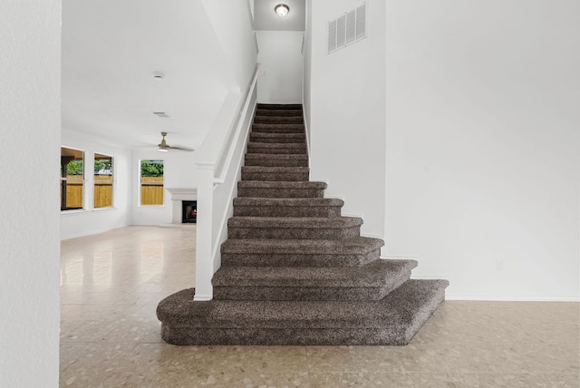 1213 Pathfinder Way, Round Rock, TX 78665 - stairs featuring a lit fireplace and ceiling fan
