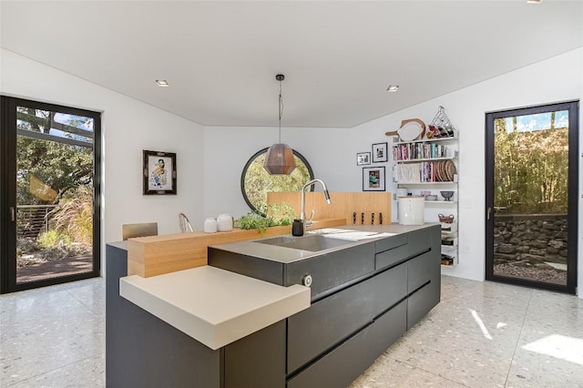 1900 Airole Way, Austin, TX 78704 - kitchen with a center island with sink, dark speckled floor, light countertops, and pendant lighting