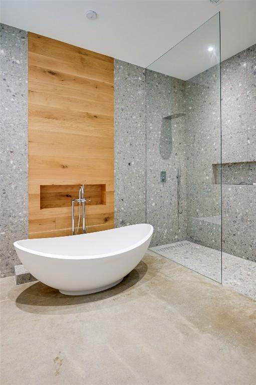1900 Airole Way, Austin, TX 78704 - bathroom with a walk in shower, a soaking tub, and wood walls