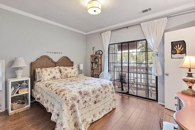 303 W 35th St Unit 202, Austin, TX 78705 - bedroom with crown molding, access to outside, wood finished floors, and a textured ceiling