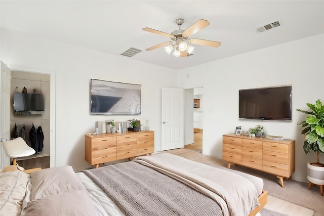 141 Ashwood N, Kyle, TX 78640 - bedroom featuring a spacious closet, ceiling fan, a closet, and light wood-style floors