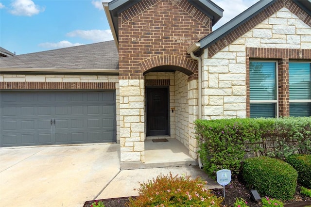 6007 Agostino Cv, Round Rock, TX 78665 - property entrance featuring stone siding, an attached garage, concrete driveway, and a shingled roof