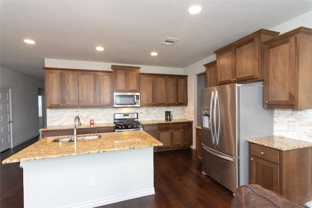 6007 Agostino Cv, Round Rock, TX 78665 - kitchen featuring stainless steel appliances, dark wood-style floors, light stone counters, recessed lighting, and brown cabinetry