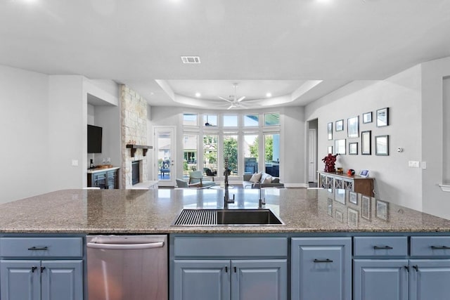 1720 Boscello Ct, Leander, TX 78641 - kitchen featuring open floor plan, dishwasher, ceiling fan, a raised ceiling, and an island with sink