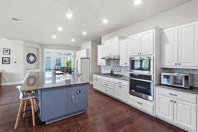 1720 Boscello Ct, Leander, TX 78641 - kitchen featuring appliances with stainless steel finishes, tasteful backsplash, white cabinets, and recessed lighting