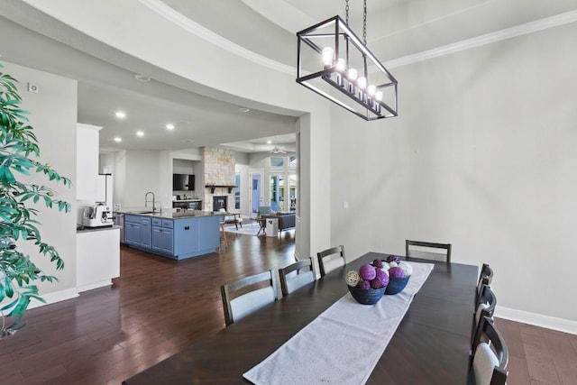1720 Boscello Ct, Leander, TX 78641 - dining space with dark wood finished floors, ceiling fan, recessed lighting, crown molding, and a stone fireplace