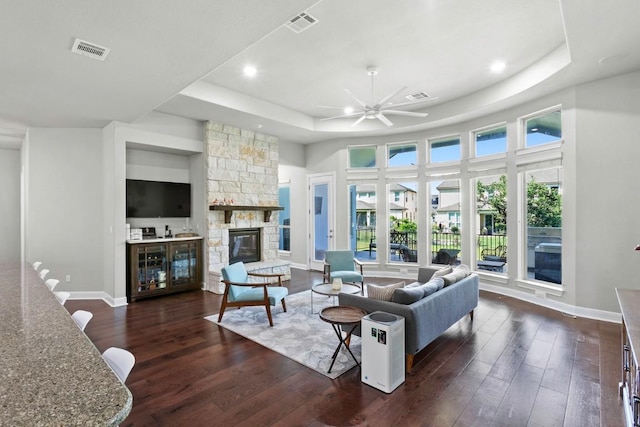 1720 Boscello Ct, Leander, TX 78641 - living area featuring a raised ceiling, dark wood-type flooring, ceiling fan, a fireplace, and recessed lighting