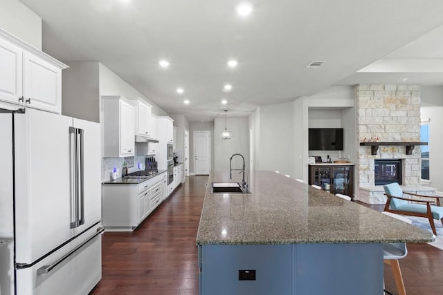 1720 Boscello Ct, Leander, TX 78641 - kitchen with stainless steel appliances, recessed lighting, a large island, dark wood-style flooring, and a kitchen breakfast bar