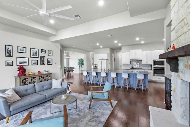 1720 Boscello Ct, Leander, TX 78641 - living area with ceiling fan, dark wood-style floors, a fireplace, and recessed lighting