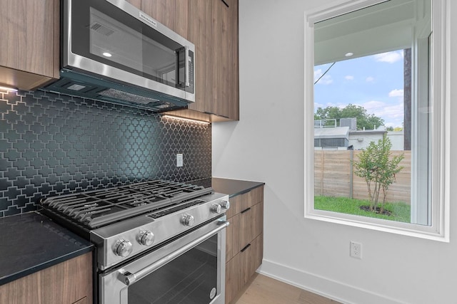 54 Robert T Martinez Jr St, Austin, TX 78702 - kitchen featuring stainless steel appliances, modern cabinets, dark countertops, backsplash, and brown cabinets
