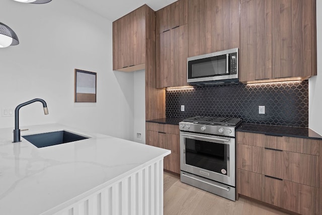 54 Robert T Martinez Jr St, Austin, TX 78702 - kitchen with stainless steel appliances, modern cabinets, dark stone countertops, and tasteful backsplash